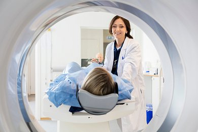 Blick durch ein MRT: Patient wird von einer radiologischen Fachperson für einen Scan vorbereitet.
